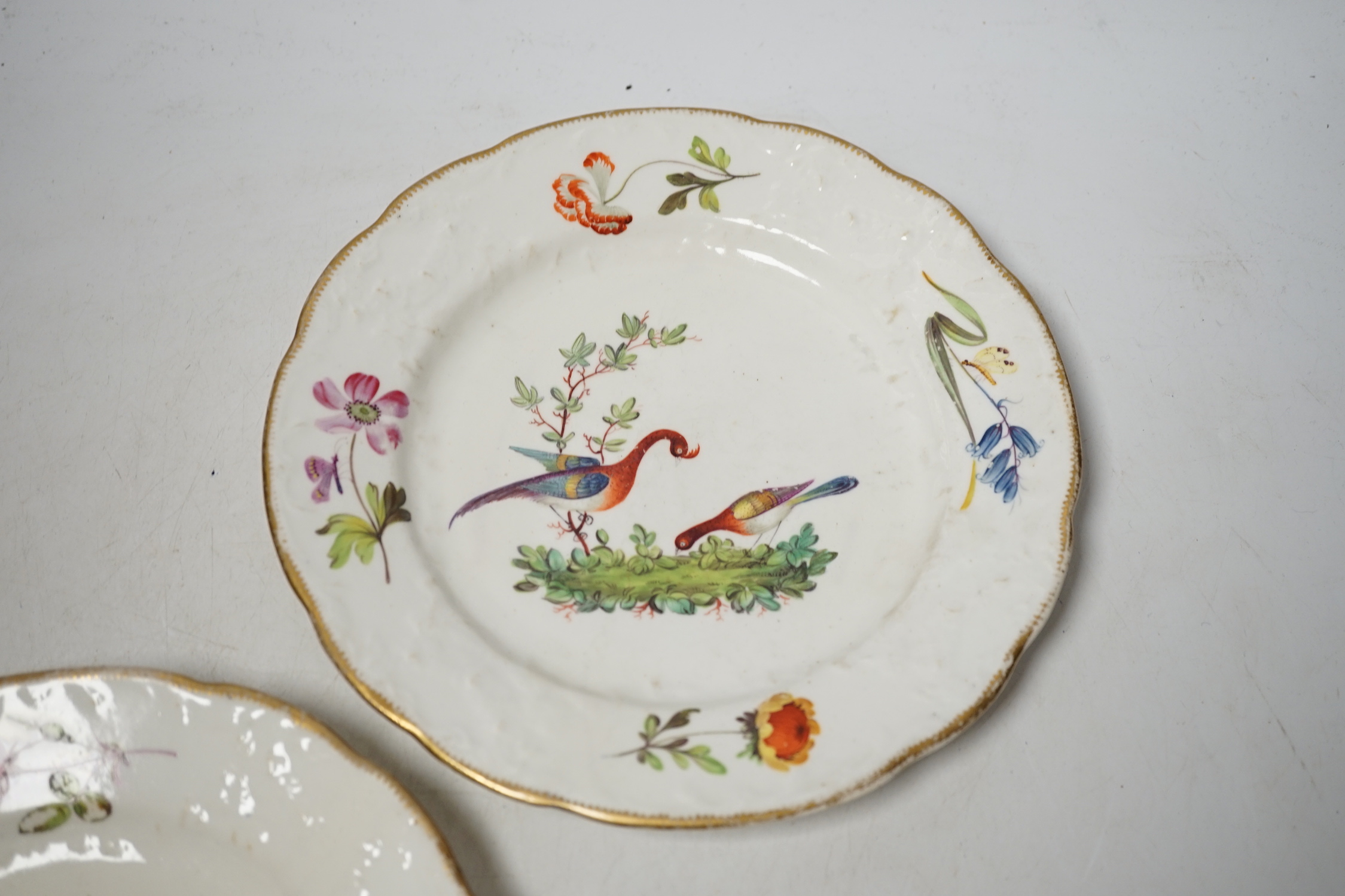 A pair of Nantgarw porcelain plates, hand painted with birds and flowers, 22cm in diameter